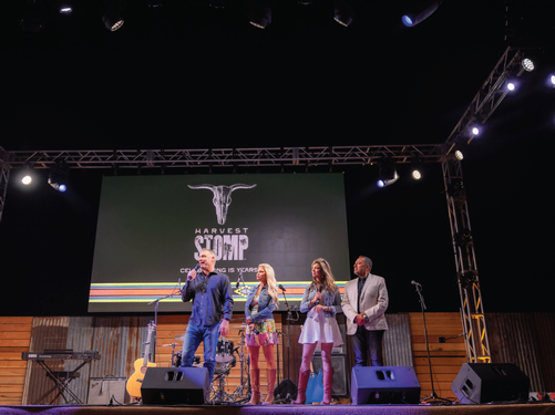 Image of John and Michele Truchard speaking on stage at the Harvest STOMP philanthropic community event in Napa Valley.