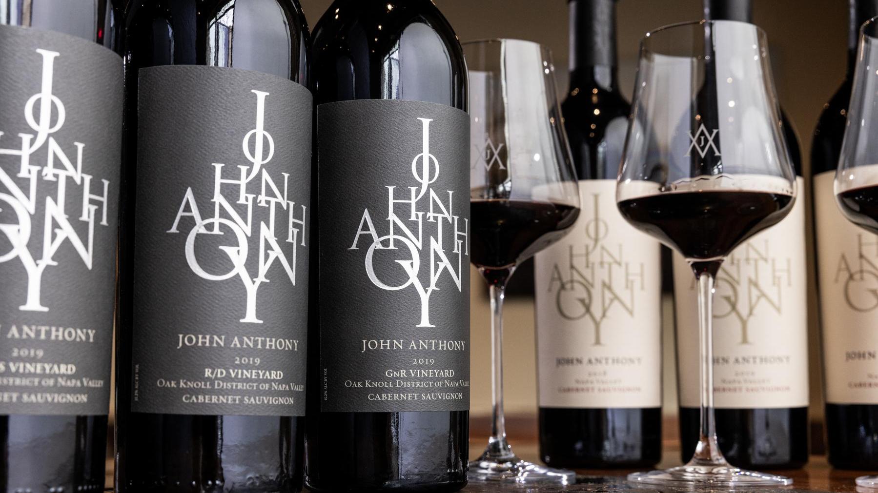 Photo of John Anthony Vineyards Cabernet Sauvignon bottles, showcasing the rich, deep hues of the wine. The elegant labels and dark glass reflect the premium quality of these wines, known for their bold flavors and prestigious reputation as the 'King of Reds' in Napa Valley.