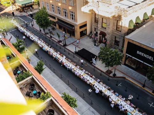 Exterior view of John Anthony Vineyards' downtown Napa tasting lounge bustling with activity on a vibrant afternoon.